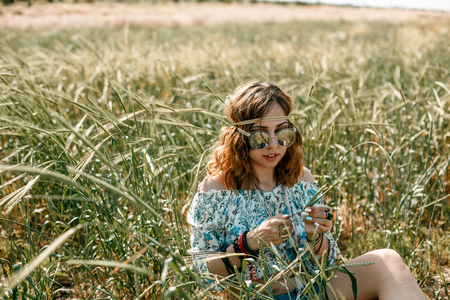 portrait of a young hippie girl on a wheat fieldの写真素材