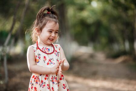 portrait of a little cute Caucasian girl in vintage clothes posing in the woodsの写真素材