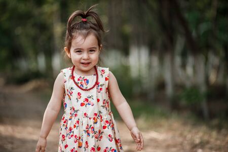 portrait of a little cute Caucasian girl in vintage clothes posing in the woodsの写真素材