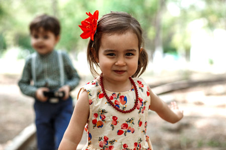 little boy and girl in vintage clothes with vintage suitcase and with vintage camera on abandoned...