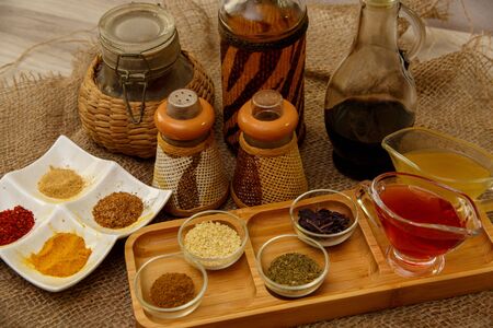 different types of spices in different containers on wood and canvasの写真素材