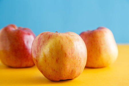 fresh apples on yellow-blue background