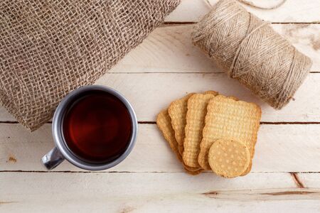 tea in vintage mug and cookies on canvasの写真素材