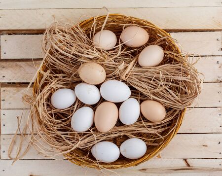 raw eggs in the hay on a wooden backgroundの写真素材
