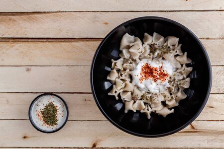 Turkish Manti manlama on plate with red pepper, tomatoes sauce, yogurt and mintの写真素材