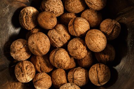 walnuts on a wooden table and in iron utensilsの写真素材