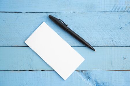 paper notebook and black pen on blue wooden background. the view from the topの写真素材