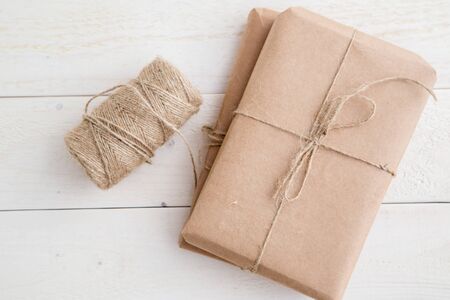 parcel,gift Packed in eco-friendly paper and twine for packing on light wooden background. the view from the topの写真素材