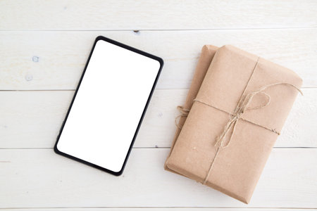 parcel,gift Packed in eco-friendly paper and tablet on light wooden background. the view from the...