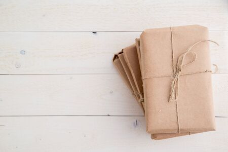 parcel,gift Packed in eco-friendly paper on light wooden background. the view from the topの写真素材