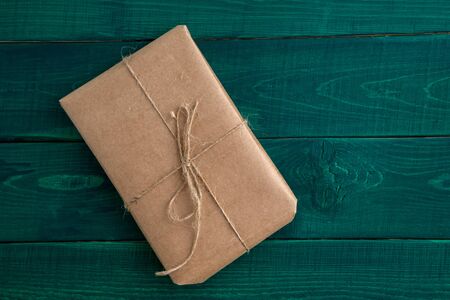 parcel,gift Packed in eco-friendly paper on dark green wooden background. the view from the topの写真素材