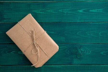 parcel,gift Packed in eco-friendly paper on dark green wooden background. the view from the topの写真素材