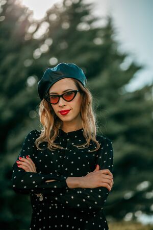 Young  woman in vintage black polka dot dress posing outsideの写真素材