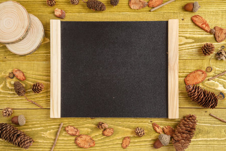 Acorns and a Board with space for text on a green grunge wooden