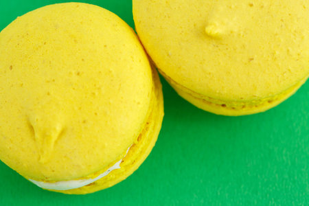 Colorful macarons or macaroons cookies on green