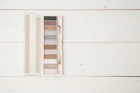 eye shadow and brush on light wooden background. flat layの写真素材