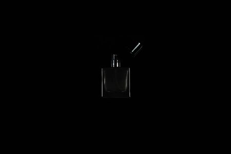 small dark perfume bottle on black isolated backgroundの写真素材