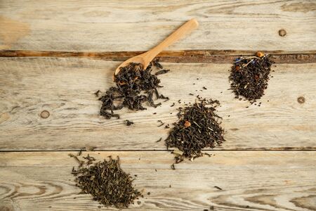 different varieties of natural tea on a bamboo spoon on a wooden backgroundの写真素材