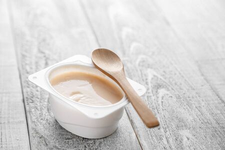 natural organic yogurt of different types on a wooden background with a natural bamboo spoon. selective focus, small focus areaの写真素材