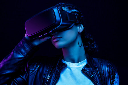 African-American young woman in vr glasses watching 360 degree video with a virtual reality headset...