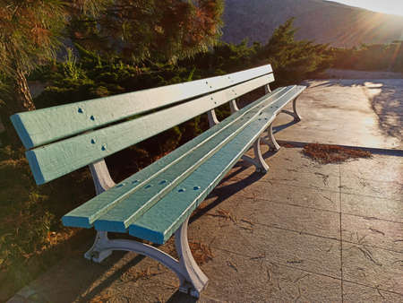 blue Park bench in summer at sunset.の写真素材
