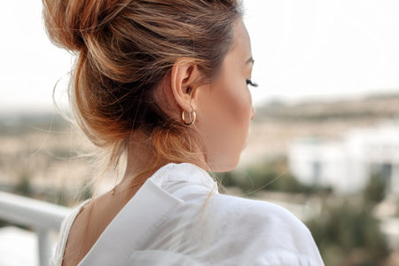 young beautiful Asian woman in beige lace shorts,white shirt in the morning . selective focus: a...
