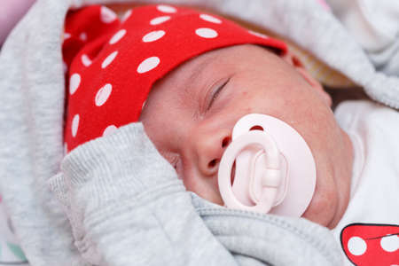 baby pacifier in the mouth of a crying month-old baby. close up. low depth of focus, selective focus.の写真素材