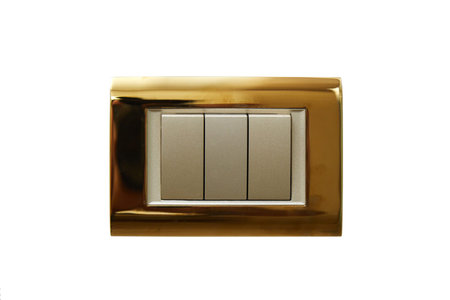 wall-mounted electric switch or socket in a gold-plated frame on a white isolated background.
