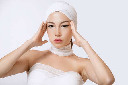 ffashionable portrait of a young beautiful Asian woman in bandages on an isolated background.の写真素材
