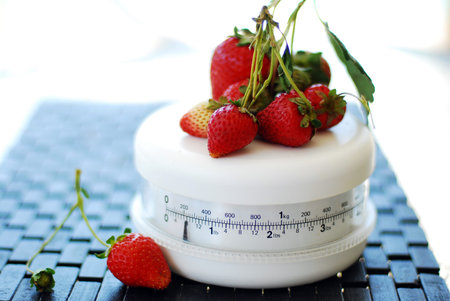 red ripe strawberries on the white scale