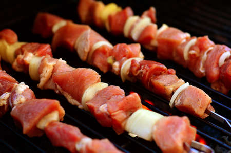 Roasted vegetables and shishkebab marinated in oil and spices on the grill outside.の写真素材