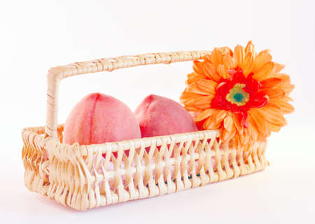 Fresh ripe yellow peaches in a basket on a white background.の写真素材