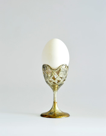 Egg on a silver stand on a white background.の写真素材