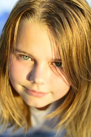 Little beautiful girl in white clothes emotions on a blue background.の写真素材