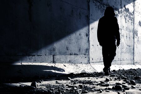 A man going out of an abandoned tunnel leaving a strong shadow behind. Man going to light.の写真素材