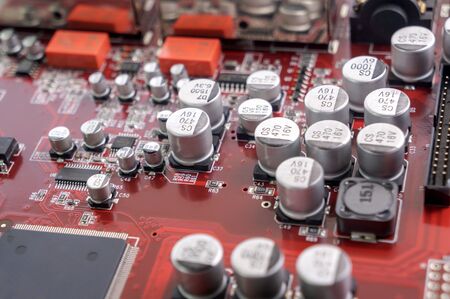 Red circuit board with electronic components.の写真素材