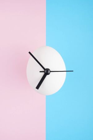 Egg-clock on colorful a pink-blue background.の写真素材