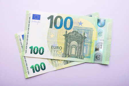 One hundred euro banknotes on purple background. EU currency banknotes. Two hundred euro.