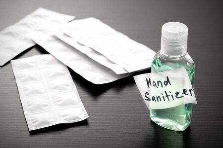 Antibacterial alcohol-containing hand sanitizer in a plastic bottle. Hand sanitizer in green color on a wood table. Antibacterial hand gel.の写真素材
