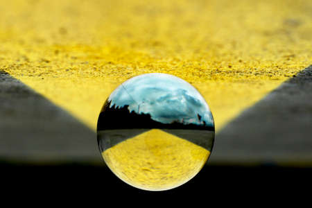 A lens ball with blurry image insigde and a yellow and grey blackground.の写真素材