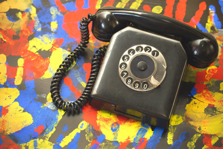Vintage landline telephone on a vivid colorful background.