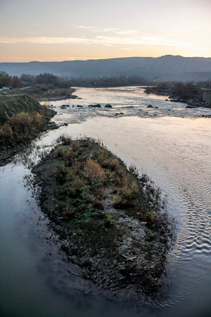 Isolated dirty and polluted island in a river.の写真素材