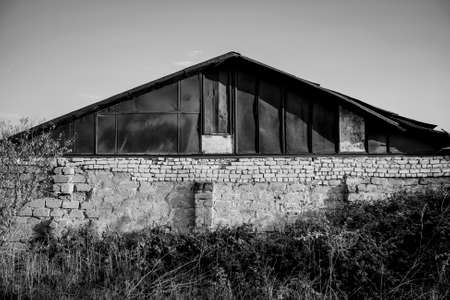 Old ugly building with a rusty roof in black and white.の写真素材