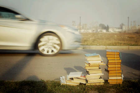 Thrown away bunch of old books lying by the road on the grass.の写真素材