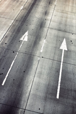 Autobahn top view. White parallel directional arrown on a highway.