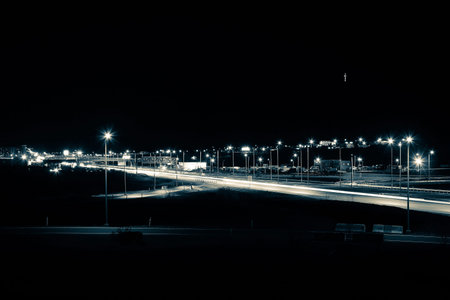 Long distance view of a freeway at night in blue monochrome.