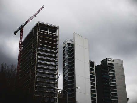 Modern multistory residential buildings under construction. Evening scene with buildings and lifting cranes.の写真素材