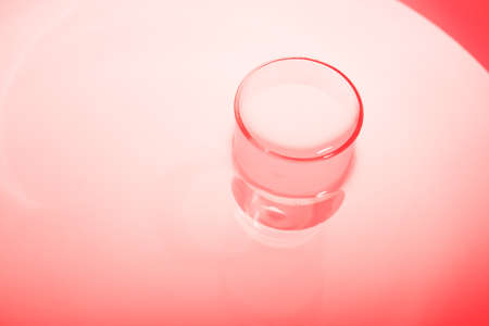Abstract red shiny surface with a round object. Water in water. Abstract red background.の写真素材