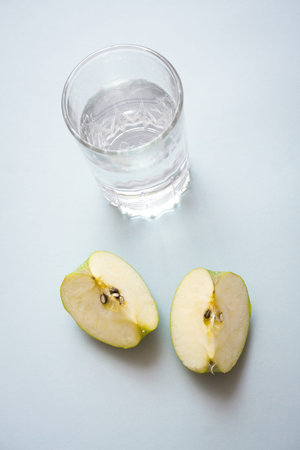 Pieces of apple and a glass of cold water with free copy paste space. Healthy lifestyle and dieting...