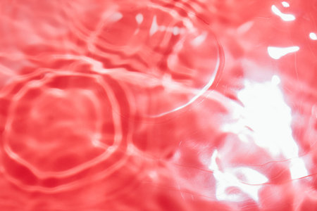 Red abstract background in blur. Blurry liquid surface with ripples.